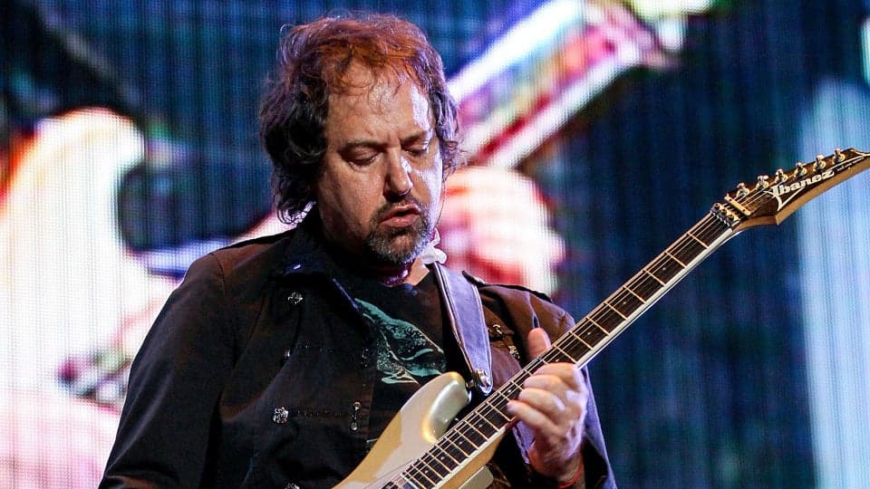 Alejandro Marcovich tocando la guitarra en un concierto, reconocido músico de la banda Caifanes, en un momento de interpretación.