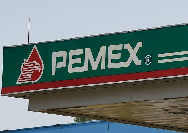 Logo de Pemex en una estación de servicio, simbolizando la empresa estatal y su reciente mejora financiera.