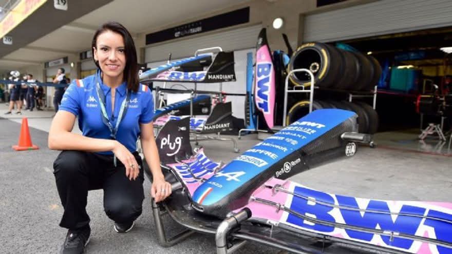 Dalia Carolina Ramos Guerra posando junto a un auto de Fórmula 1 del equipo Alpine en un taller, destacando su papel en la