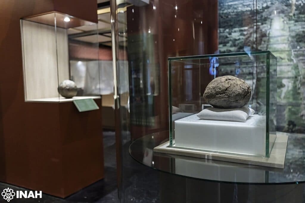 Pelota de hule de 3,600 años en exhibición en la Zona Arqueológica de Teotihuacan, destacando su importancia cultural y ancestral.