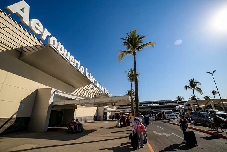 Aeropuerto Internacional de Guadalajara con pasajeros esperando, reflejando la conexión a destinos nacionales para el giveaway de Mundo Jalisco.