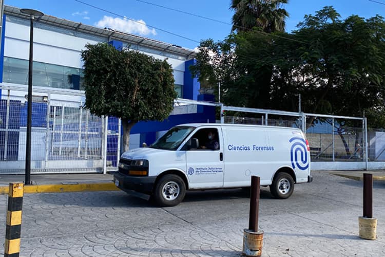 Furgón de Ciencias Forenses frente a un edificio, utilizado para la identificación de personas en inhumaciones clandestinas en Jalisco.