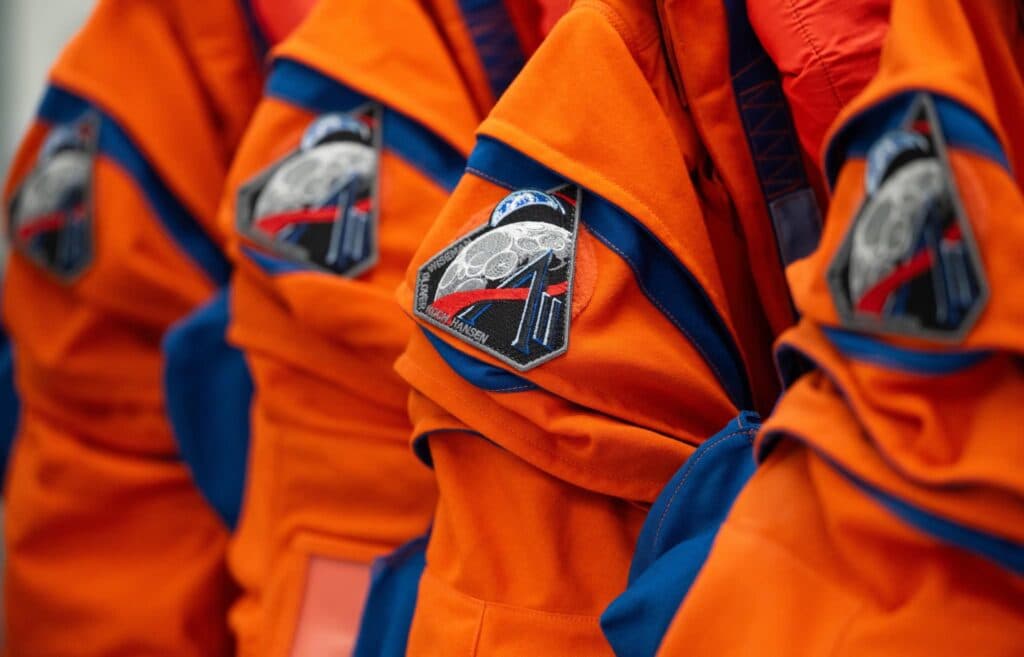 Uniformes de astronautas de la misión Artemis III de la NASA, con parches que representan la exploración lunar.
