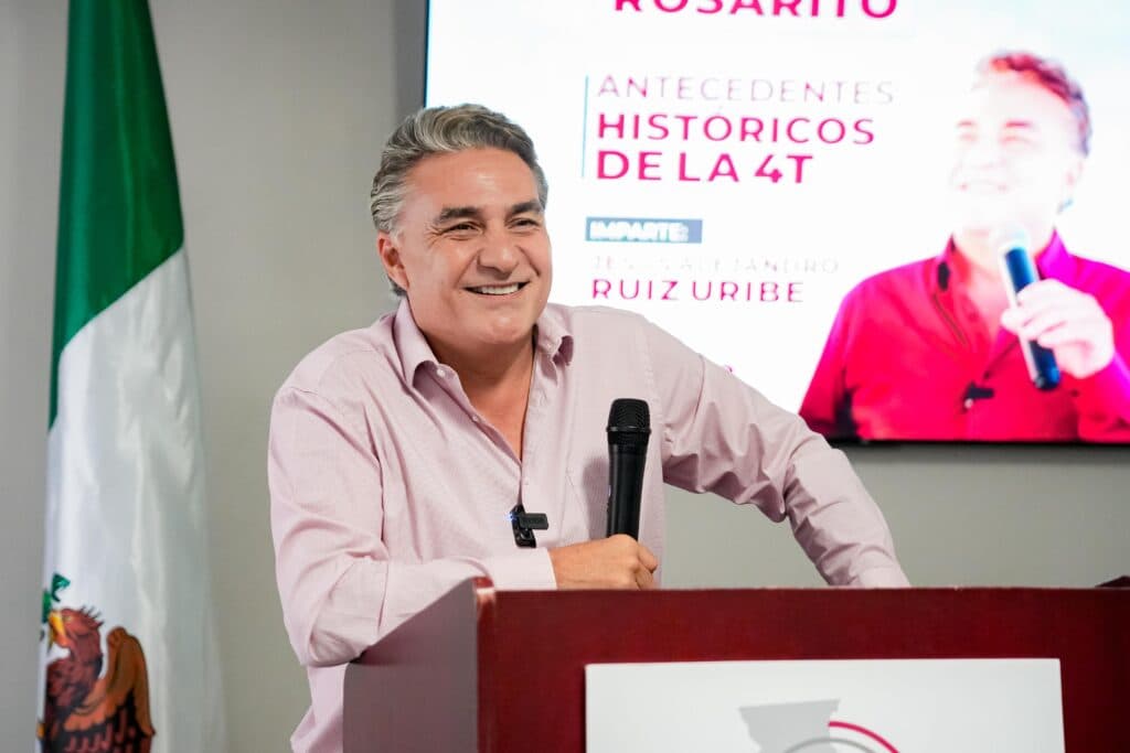 Jesus Ruiz Uribe sonríe mientras habla en un evento en Casa Morena de Rosarito, destacando la Cuarta Transformación y temas sociales.
