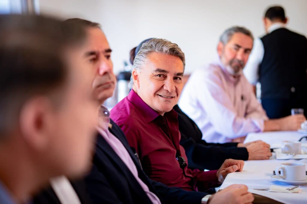 Jesús Ruiz Uribe sonríe mientras participa en una reunión con el Grupo Unidos por Tijuana, abordando temas de desarrollo y seguridad.