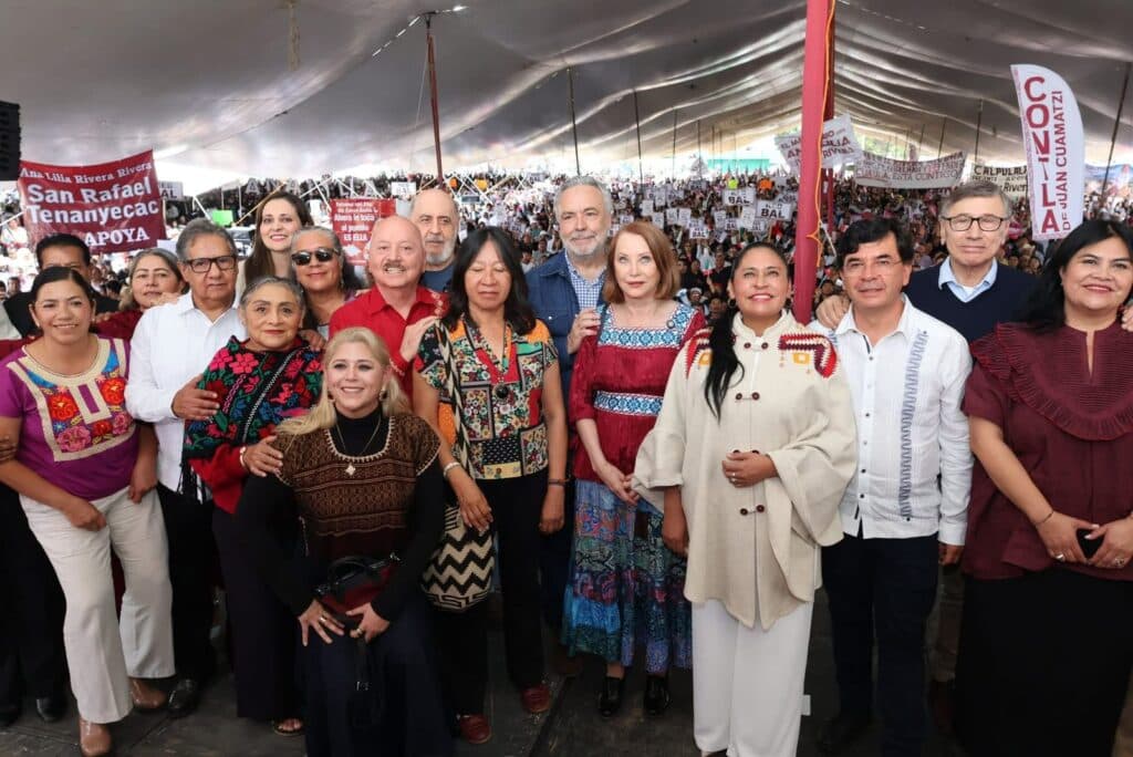 Senadora Ana Lilia Rivera rodeada de asistentes en su Segundo Informe de Actividades, con pancartas y senadores presentes en Tlaxcala.