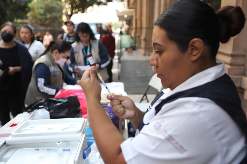 Trabajadora de salud preparando una vacuna contra el sarampión en un módulo de vacunación en Guadalajara, Jalisco, durante el Mundial de Fútbol.