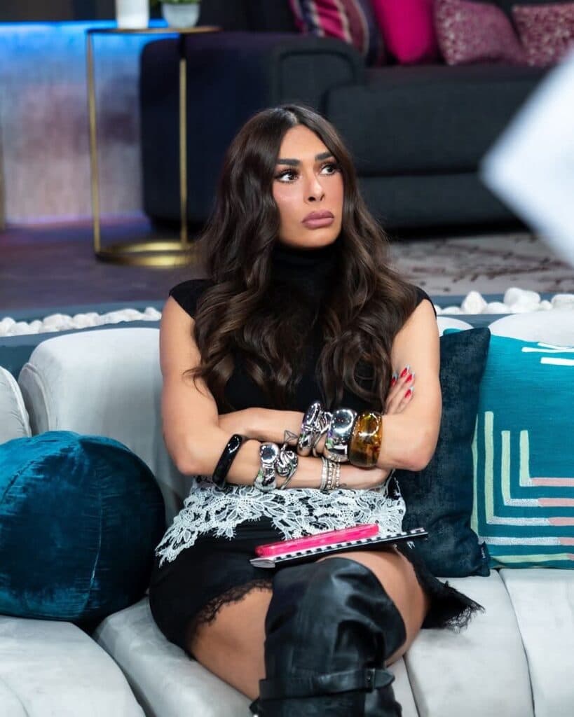 Galilea Montijo sentada en un sofá, con brazos cruzados y expresión seria, en el set de La Casa de los Famosos México 4.