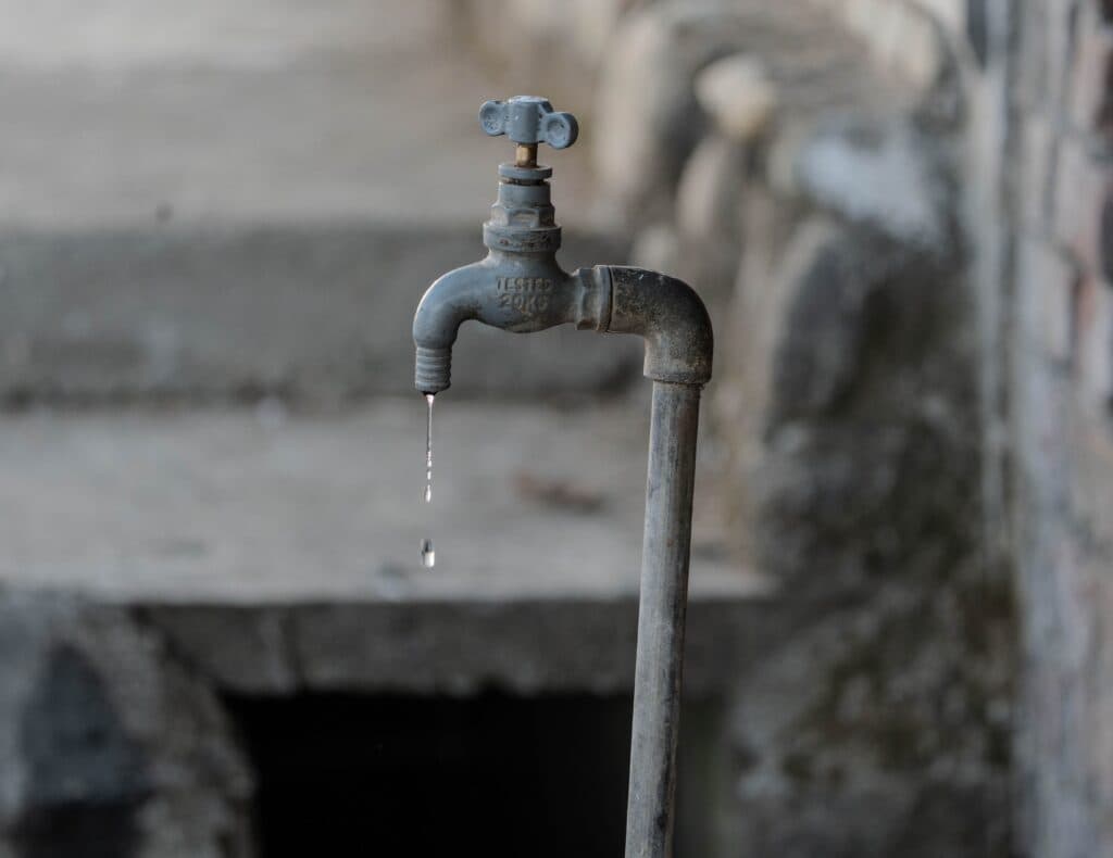 Grifo de agua en mal estado con una gota que cae, simbolizando la crisis de agua en CDMX por cortes en el suministro.