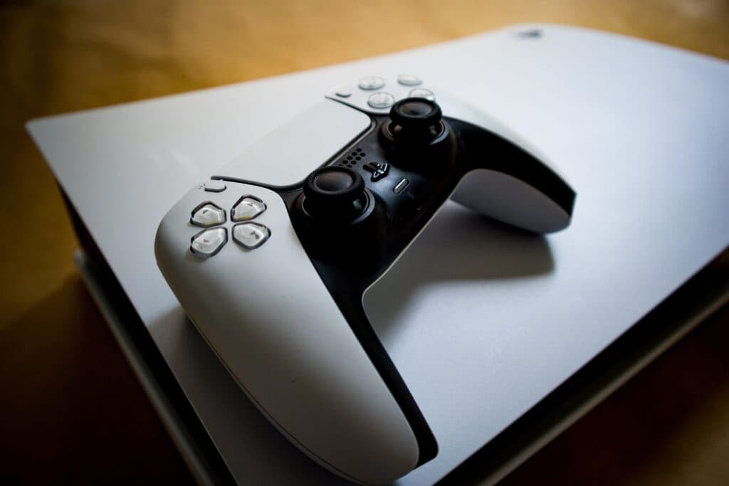 Controlador de PlayStation sobre una consola blanca, simbolizando el futuro digital de los videojuegos.