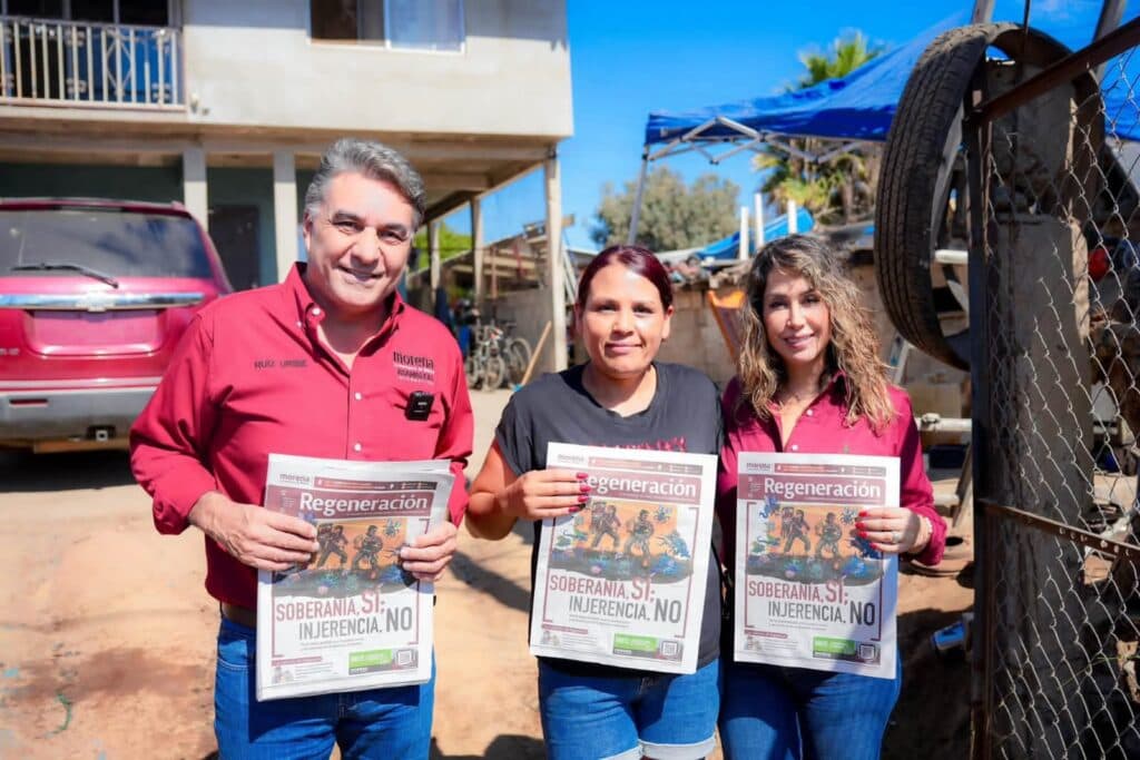 Jesús Ruiz Uribe y su esposa Marcela Valdez entregan ejemplares de "Regeneración" a una residente durante su recorrido en Ensenada.