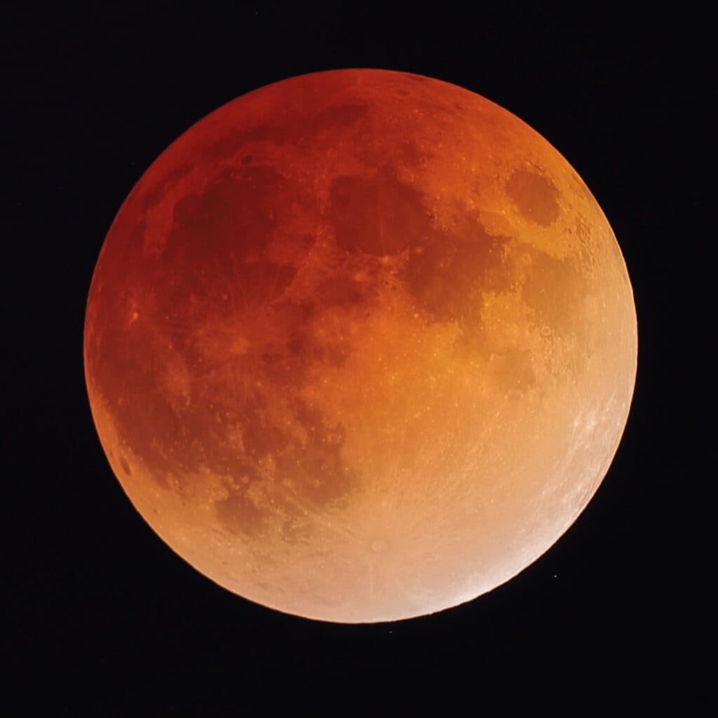 Luna de Sangre durante un eclipse lunar, mostrando tonalidades rojizas y anaranjadas en el cielo nocturno.
