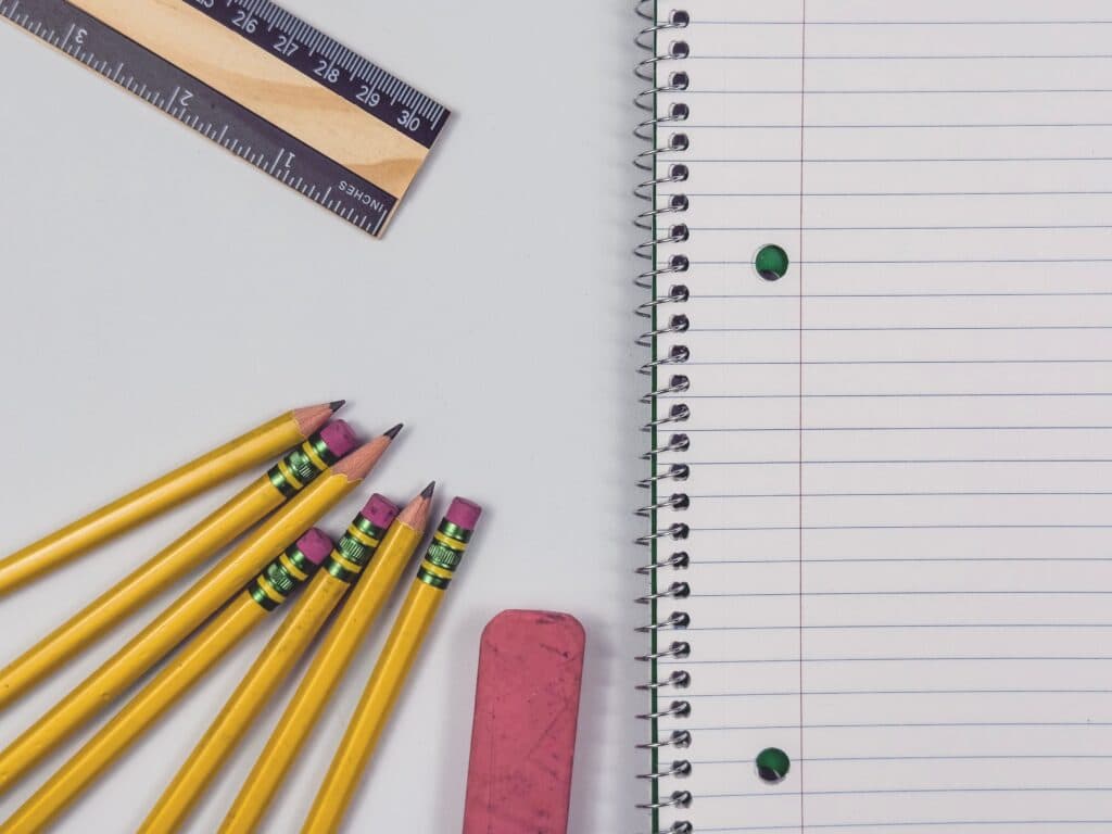 Lápices amarillos, una regla y una libreta en blanco sobre una mesa, reflejando la preparación para el regreso a clases.