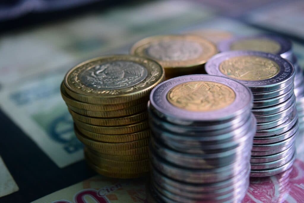 Monedas y billetes mexicanos apilados, simbolizando la economía y la inflación en México, que alcanzó un 3.12% en julio.
