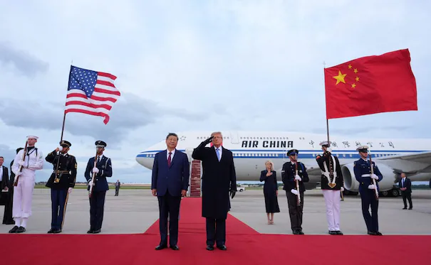 Xi Jinping y Donald Trump saludan en la base aérea Andrews, rodeados de banderas de Estados Unidos y China durante la visita de Estado.