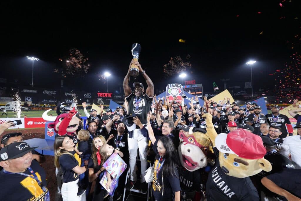 Jugadores y aficionados de los Toros de Tijuana celebran el campeonato de la LMB, levantando el trofeo en el Toros Mobil Park.