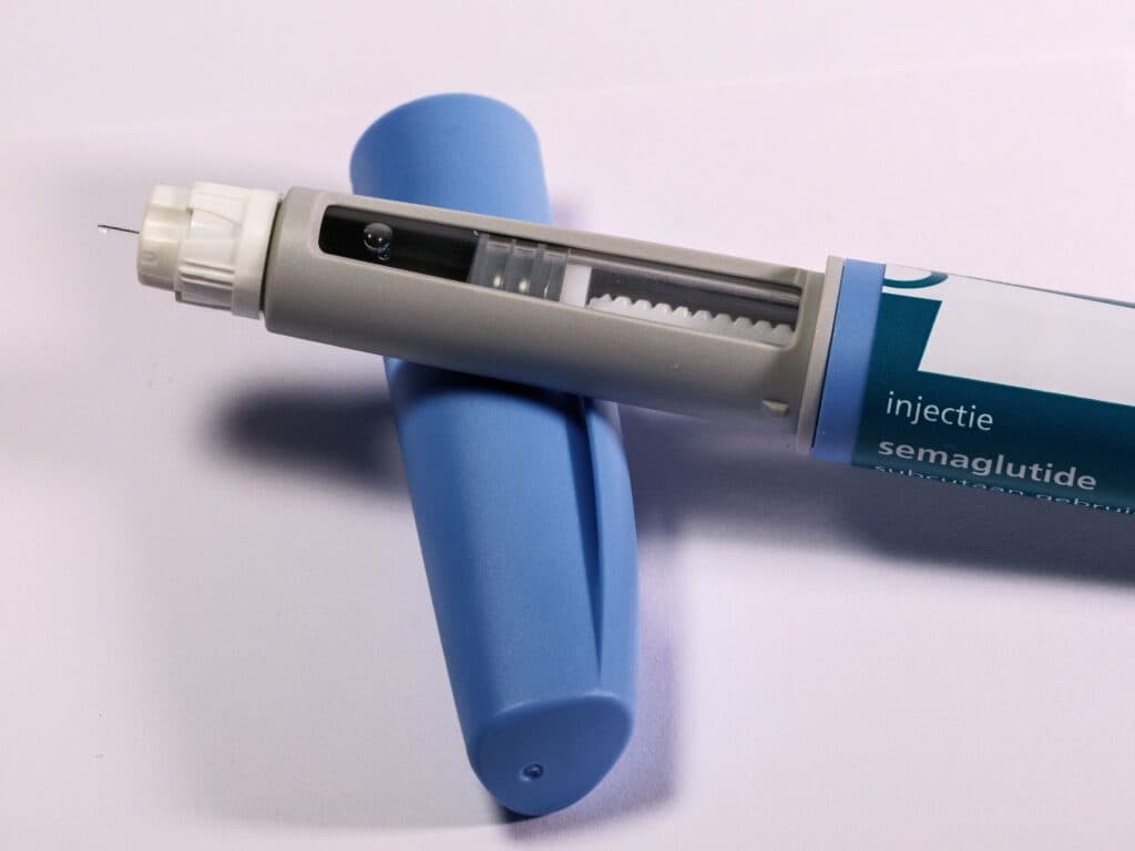 Pluma de medicamento para controlar el peso, utilizada en tratamientos de GLP-1, sobre fondo blanco.