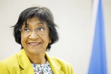 Navanethem Pillay sonríe durante una conferencia, destacando su labor en derechos humanos y justicia internacional.