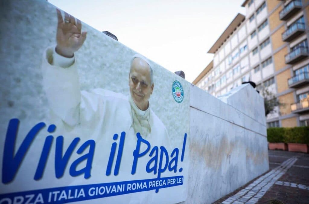 Pancarta en apoyo al papa León XIV con la frase "Viva il Papa!" colocada frente a un edificio en Roma, reflejando la preocupación por su salud.