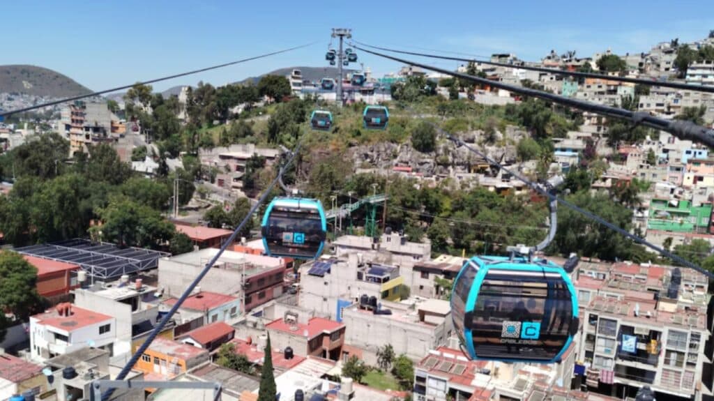 Vista panorámica del Cablebús en la Alcaldía Álvaro Obregón, con casas y colinas al fondo, simbolizando el desarrollo urbano y transporte.