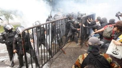 Enfrentamiento entre policías y manifestantes durante protesta por la calidad del agua en Guadalajara, con uso de gas lacrimógeno.